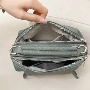 Detailed view of grey genuine leather multi-compartment handbag interior structure lining.