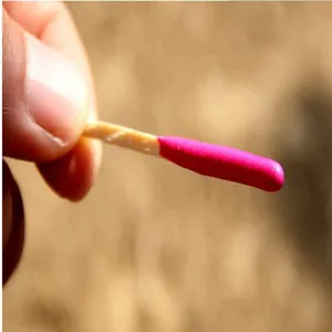 Primo piano dettagliato di un fiammifero impermeabile antivento con testa rosa viva.