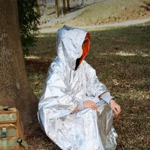 Portable aluminum foil outdoor emergency survival thermal poncho for camping and hiking use.