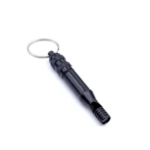 Close-up of black aluminum survival whistle with keyring and waterproof compartment.