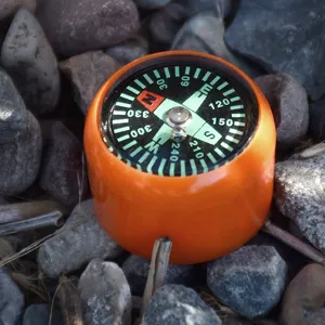 Vue detaillee mini boussole de survie exterieure orange, design bouton portable avec cadrans clairs.