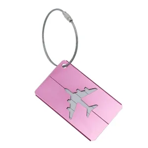 Détail d'étiquette de bagage en aluminium rose, découpe d'avion, boucle de câble.