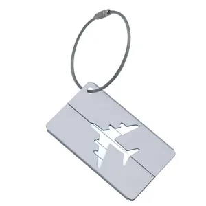 Gros plan détail étiquette de bagage en aluminium argenté avec découpe avion et câble.