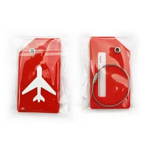 Vue détaillée d'étiquettes de bagages rouges avec motif d'avion et câble en acier.