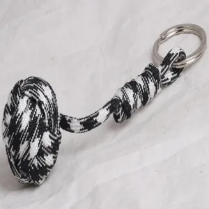 Black and white paracord survival keychain with ball knot and metal ring for outdoor use.