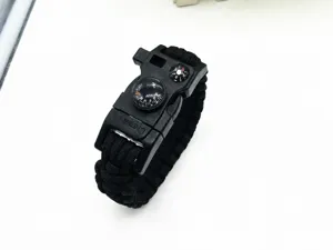 Black paracord survival bracelet with integrated compass and whistle for outdoor emergency use.