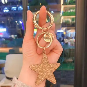 Primo piano del ciondolo portachiavi a pentagramma con strass scintillanti e dettagli oro.