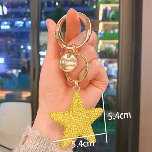 Primo piano del portachiavi a stella in strass giallo scintillante con dettagli dorati.