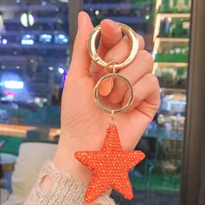 Portachiavi con stella rossa glitterata e anello oro rosa, ciondolo elegante per borsa.