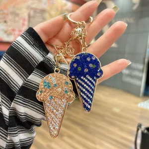 Close-up of sparkling rhinestone ice cream keychains, luxury metal handbag charms and gifts.
