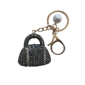 Chic rhinestone handbag keychain with glittering crystals, gold keyring and pearl charm.