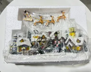 Christmas resin village scene with flying reindeer and glowing music box decoration for holiday.