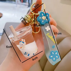 Niedlicher Acryl Milch-Tee Tassen Schlüsselanhänger mit süßem Häschen und blauem Sakura Armband.