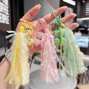 Nahaufnahme von bunten Quasten Taschenanhängern und Schlüsselanhängern in Gelb, Rosa, Grün.