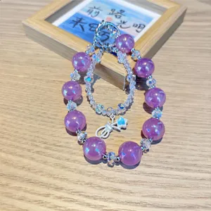 Close-up purple iridescent crystal beaded phone charm with silver star pendant detail.