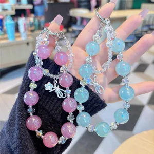 Close-up of sparkling pink and blue crystal beaded phone charms and bag chain pendants.