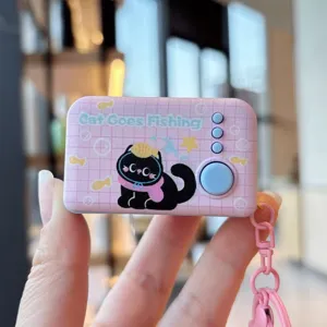 Close-up detail of a cute pink electronic decompression toy keychain with cat print and buttons.