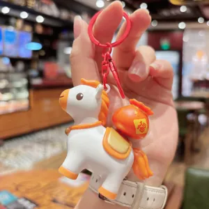 Cute cartoon horse keychain detail shot, lucky money bag pendant with vibrant orange white color.