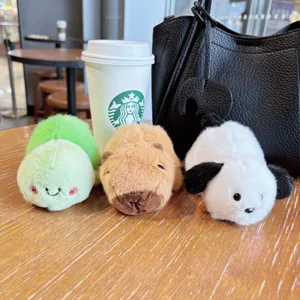 Cute plush toy pendant detail showcasing soft fabric, miniature turtle, capybara, and puppy.