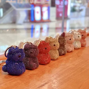 Primo piano dettagliato di portachiavi unicorno in strass colorati allineati sul legno.