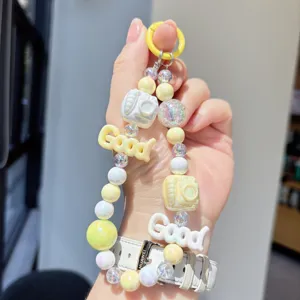 Colorful beaded phone strap detail, cute yellow macrocaron charm keychain accessory.