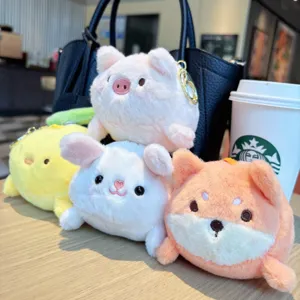 Cute plush animal keychains detail shot featuring assorted round stuffed toys on wooden table.