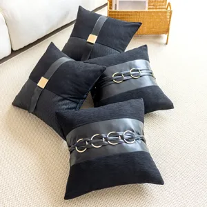 Black leather decorative pillow cover detail showing belt and metal rings design for home couch.