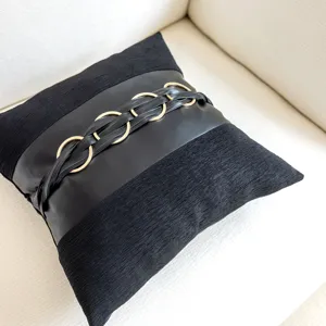 Black decorative throw pillow detail, luxury leather and gold ring accent cushion cover.
