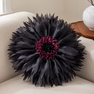 Detail view of a 3D flower throw pillow featuring layered black and burgundy petals.
