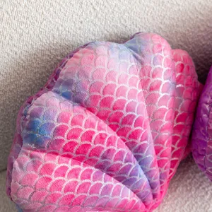 Soft plush shell pillow detail, cozy pink gradient decorative cushion close up view