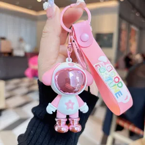 Pink astronaut dog keychain detail, cute cartoon bag charm and car key ring accessory.
