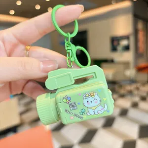 Close-up detail of the cute green camera projector keychain with lovely cat design.