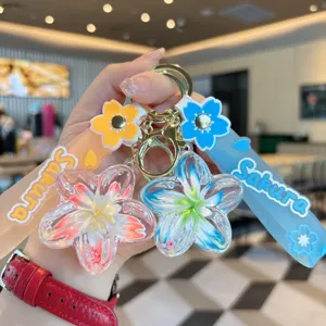 Close-up detail of creative liquid floating flower keychain with Sakura strap charm.