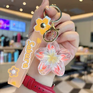 Close-up of the acrylic floating glitter plumeria keychain strap detail liquid charm accessory.