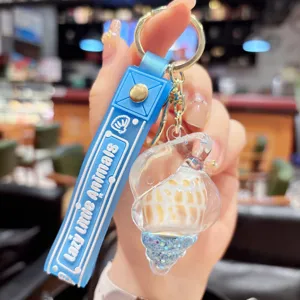 Cute summer quicksand conch keychain pendant for bags with fluid glitter design.