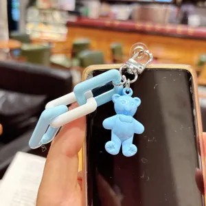 Gros plan d'un porte-clés ours en acrylique bleu et chaîne épaisse pour sac ou étui.