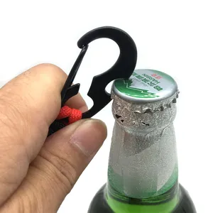 Vue détaillée d'un mousqueton décapsuleur en métal noir avec paracorde rouge ouvrant une bouteille.