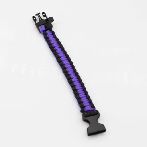 Detailed view of the black and purple woven paracord survival bracelet with plastic buckle.