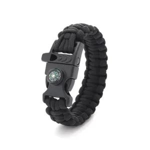 Detailed view of black paracord survival bracelet with compass and emergency whistle.