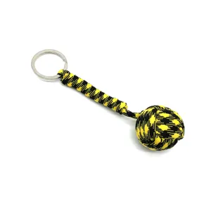 Close-up detail of black and yellow paracord monkey fist keychain, durable nylon material.