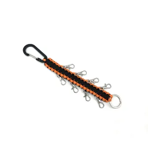 Detail shot of black and orange paracord keychain with multiple lobster clasps and carabiner.