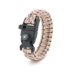 Detailed view of the survival paracord bracelet buckle featuring a built-in compass and whistle.