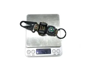 Durable paracord survival keychain featuring carabiner, whistle, and compass for outdoor use.