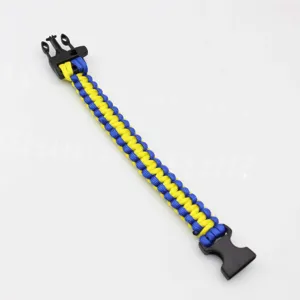 Paracord survival bracelet detail shot showing blue and yellow braided cord and plastic buckle.