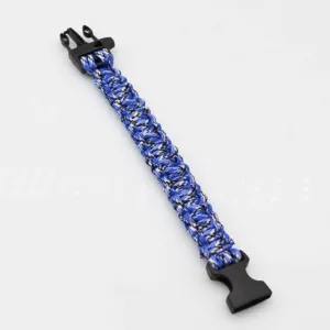 Close-up detail view of the blue and black woven paracord survival bracelet with plastic buckle.