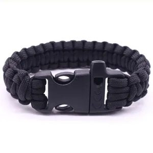 Detail view of black paracord survival bracelet with whistle buckle for outdoor emergency use.