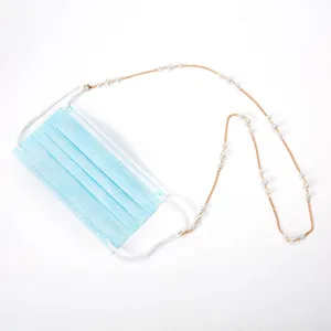 Vista detallada del accesorio de cadena de perlas doradas para mascarilla, diseño elegante.