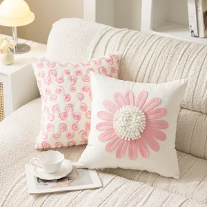 Close-up detail of pink daisy flower decorative pillowcase and soft sofa cushion for cozy home.