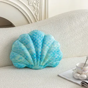 Blue seashell plush pillow detail showing soft textured fabric and shiny scale pattern close up.