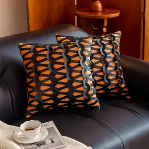 Vista detallada de la funda de cojín decorativa negra y naranja, estilo europeo para sofá.